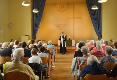 Vor vollen Stuhlreihen predigte Pastorin Sabine Behrens beim letzten Gottesdienst im Gemeindehaus. Foto: Andrea Hesse