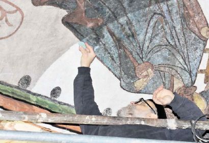 Vorsichtig befreit Reinhold Gonschior die Deckengemälde in St. Nikolai von ihrem dunklen Schleier. Bild: Bahl