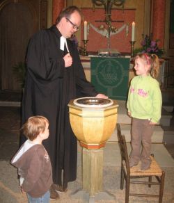 Sophie Schmidt will sich am Sonntag durch Pastor Rainer Müller-Jödicke an ihre Taufe erinnern lassen, und Bruder Jan schaut zu.