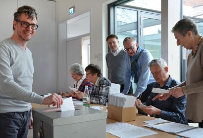 Johannes Böttcher, selbst Kandidierender für den Kirchenvorstand, gibt seine Stimme im Wahllokal der Emmaus-Kirchengemeinde in Langenhagen ab, während der Wahlvorstand die eingegangenen Wahlbriefe bearbeitet. Foto: Andrea Hesse
