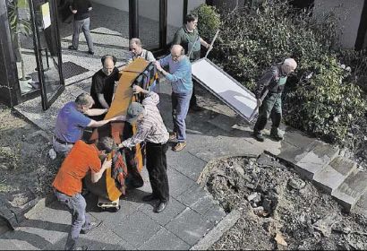 Knochenarbeit: Freiwillige befördern den Flügel aus dem Gemeindehaus in den alten Kindergarten. Foto: Lauber