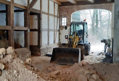 Ein Bagger steht zwischen Schuttbergen in der Elzer Pfarrscheune.