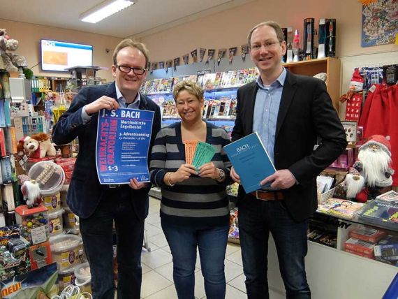 Kantor Arne Hallmann (mit Notenbuch) und Pastor Müller-Jödicke brachten Melanie Klaves die Eintrittskarten für den Vorverkauf in den Laden „Schreibwaren Nitschke“ in der Heidestraße in Engelbostel.