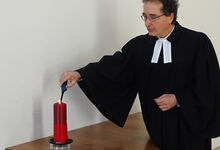 In der Pauluskirche in Langenhagen zündet Pastor Frank Foerster eine Kerze zum Gedenken an die Opfer der Covid-19-Pandemie an. Foto: GunterM