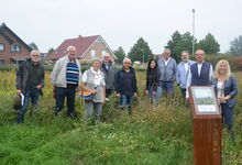 Matthias Müller (4. von links) und Pastor Karsten Henkmann (4. von rechts) mit Unterstützer:innen auf der Blühwiese. Foto: Andrea Hesse