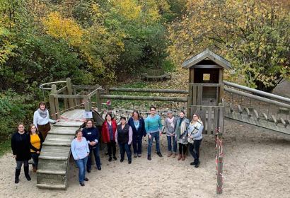 Erzieherinnen und Erzieher der Emmaus-Kindertagesstätte mit Kita-Leiterin Martina Schreiber (3. von links) und Fundraiserin Anke Kappler (vorne) vor dem maroden Klettergerüst.