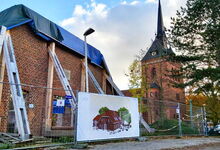 Ein Transparent am Bauzaun zeigt, wie das Gemeindezentrum einmal aussehen soll. Foto: Dorothee Tauber