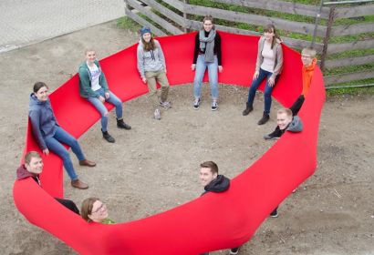 Mit einem riesigen, elastischen roten Tuch schwingt sich das Team auf die Zeit in Mardorf ein. Foto: Andrea Hesse