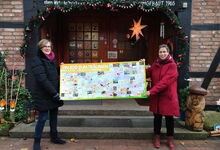 Frauke Kiel (links) freut sich über die von Christiane Kiesé überreichte Bücherkiste und das Plakat zum Zooprojekt. Foto: Birte Kiesé