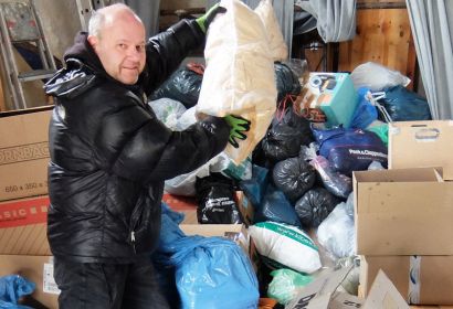 Küster Thomas Müller stapelt alle Spenden für die Kleidersammlung im Engelbosteler Martinskirchturm.