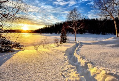 Weg durch tiefen Schnee, aufgehende Sonne, Bäume