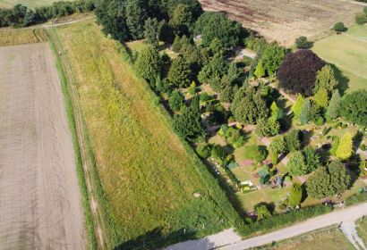 Auf der langgezogenen früheren Ackerfläche links des Brelinger Friedhofes soll der Ereignispark entstehen. Foto: Christian Bernstorf