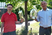 Superintendent Holger Grünjes (rechts) und Tilmann de Boer, Vorsitzender der Kirchenkreissynode und Kirchenvorsteher in der Emmaus-Kirchengemeinde, gratulieren „Emma und Paul“. Foto: Frank Foerster