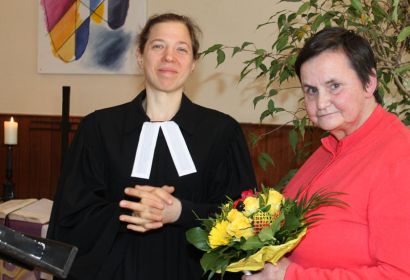 Jutta Schräpel organisiert seit 20 Jahren den Seniorenkreis; Pastorin Debora Becker sagt Danke mit Blumen und einem Buchgeschenk. Foto: Friedrich Bernstorf
