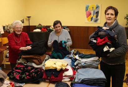 Inge Burkhardt (von links), Jutta Schräpel und Marion Bernstorf sortieren die Kleiderspenden im Gemeindesaal.