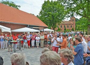 Vor der schönen Kulisse der St.-Marcus-Kirche weihten Gemeindeglieder und Gäste das neue Gemeindezentrum ein. Foto: Sonja Tiemeyer