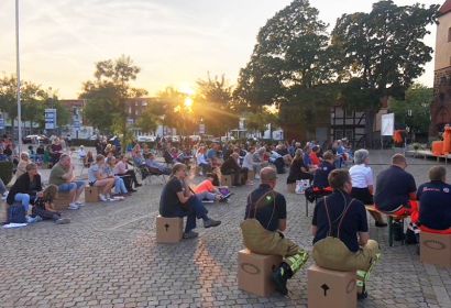 Auf Kirchentagshockern und mitgebrachten Stühlen verfolgten die Besucher*innen den Abendgottesdienst. Foto: Caroline von Blanckenburg