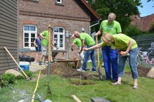Kitaleiterin Yvonne Dorsch prüft, ob die Helfer von Johnson Controls schon tief genug gegraben haben. Foto: Andrea Hesse