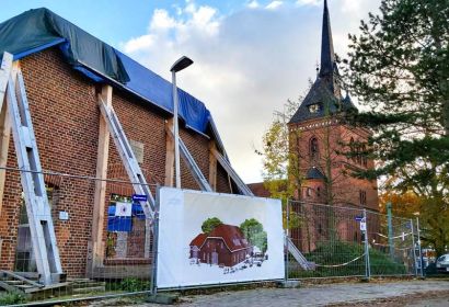 Ein Transparent am Bauzaun zeigt, wie das Gemeindezentrum einmal aussehen soll. Foto: Dorothee Tauber