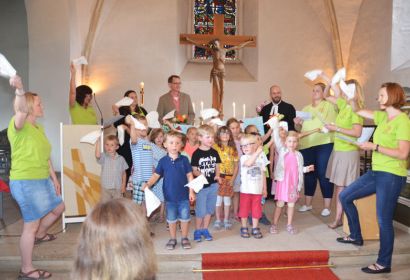 Mit flatternden weißen Taschentüchern verabschiedete die Kita St. Marien Diakon Lars Arneke (hinten links) und Pastor Fabian Garmann. Foto: Andrea Hesse