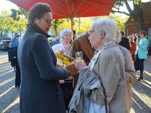 Pfarramtssekretärin Andrea Bode (links) bot auf dem Kirchplatz frische Brezeln an.
