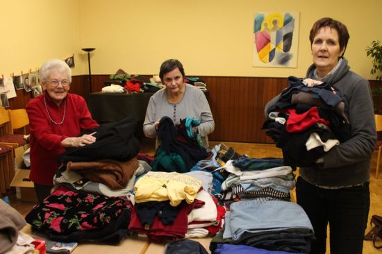 Inge Burkhardt (von links), Jutta Schräpel und Marion Bernstorf sortieren die Kleiderspenden im Gemeindesaal.