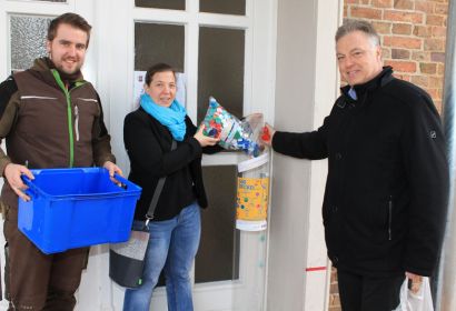 Rotary-Präsident Christian Rimpler (rechts) und Pastorin Debora Becker füllen die ersten 500 Deckel in die Sammelröhre, Paul Bernstorf sorgt für den Weitertransport zur Spedition.