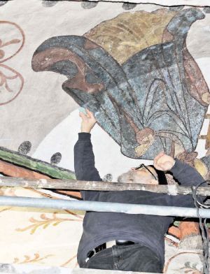 Vorsichtig befreit Reinhold Gonschior die Deckengemälde in St. Nikolai von ihrem dunklen Schleier. Bild: Bahl