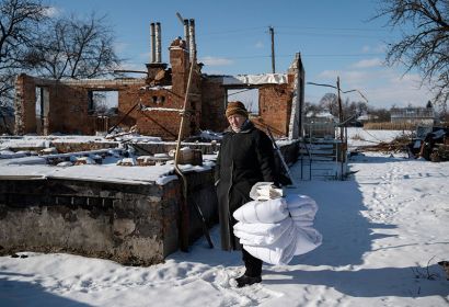 7. Februar: Anna Yurchenko vor ihrem zerstörten Haus in Ivanivka. Dank der Winterhilfe der Partnerorganisation Vostok SOS erhielten sie und ihre Nachbarn warme Decken. Foto: Siegfried Modola, Diakonie Katastrophenhilfe