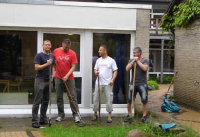 Mit Hacke und Spaten drängten die vier Ricoh-Mitarbeiter den Wildwuchs im Garten der Kita zurück. Foto: K. Cordes