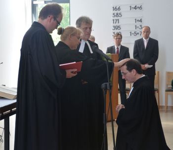Pastor Rainer Müller-Jödicke (von links), Birgit Birth und Ulrich Marahrens segnen Dr. Frank Foerster. Foto: A. Hesse