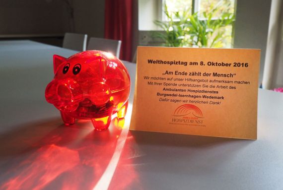 Rote Plastikschweinchen werben rund um den Welthospiztag um Spenden.