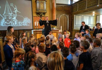 „Jeden Tag geht Gott mit euch“: Landesbischof Ralf Meister spricht den Segen für die Schulanfängerinnen und -anfänger. Foto: Jens Schulze