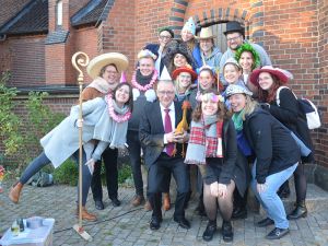 Gruppenbild mit Huhn und Hüten: Superintendent Dirk Jonas mit der Evangelischen Jugend vor der Fotobox.