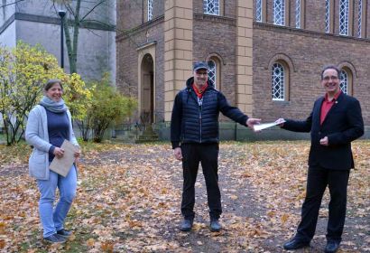 Kreisarchivpfleger Dr. Frank Foerster (rechts) und Pastorin Debora Becker überreichen Ralf Backhaus eine Kopie des alten Kaufvertrages. Foto: Andrea Hesse