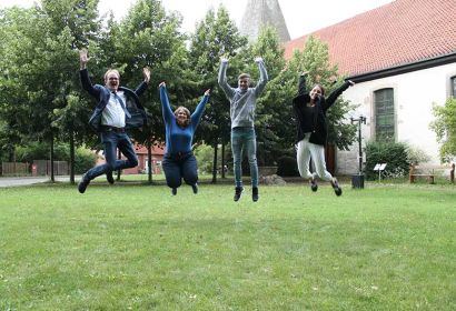 (Foto: Christian Frehrking): Pastor Rainer Müller-Jödicke jubelt mit Ann-Marie Hamburg, Florian Stelloh und Birte Kiesé (v.l.n.r.) vor der Martinskirche über den Geldsegen aus Hildesheim.