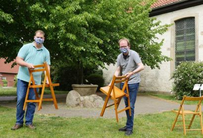Stephan Mörke (links) und Rainer Müller-Jödicke stellen vor der Martinskirche schon einmal ein paar Klappstühle bereit. Foto: Christian Frehrking