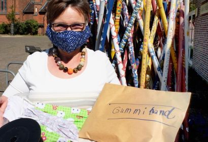 Bettina Praßler-Kröncke zeigt einen Teil der handgenähten Masken und des gespendeten Gummibandes.