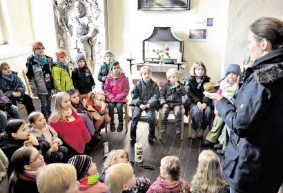Insa Dempwolff erläutert der etwa 30-köpfigen Kindergruppe die Bedeutung von Kerzen in der Kirche. Foto: Knoche