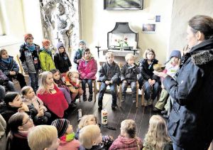 Insa Dempwolff erläutert der etwa 30-köpfigen Kindergruppe die Bedeutung von Kerzen in der Kirche. Foto: Knoche