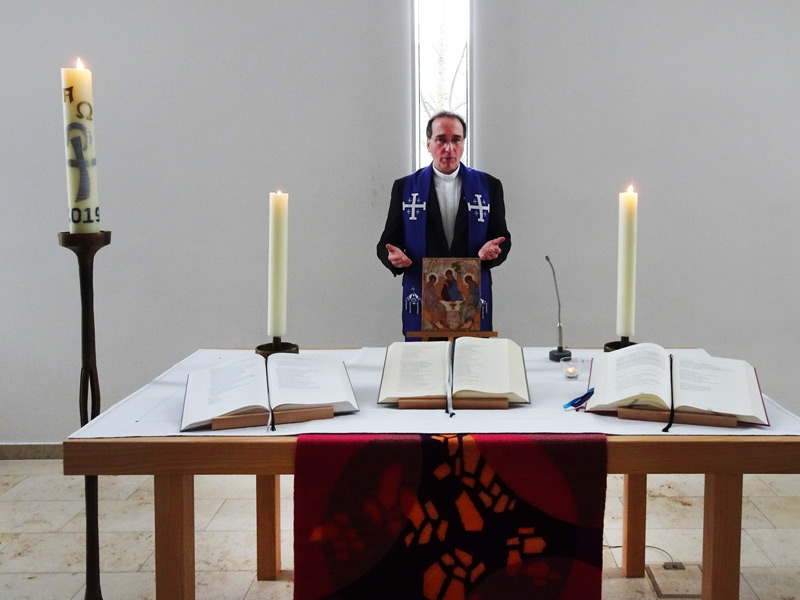 Pastor Frank Foerster betet am Altar der St.-Paulus-Kirche und lädt dazu ein, zeitgleich mit ihm zu Hause zu beten.