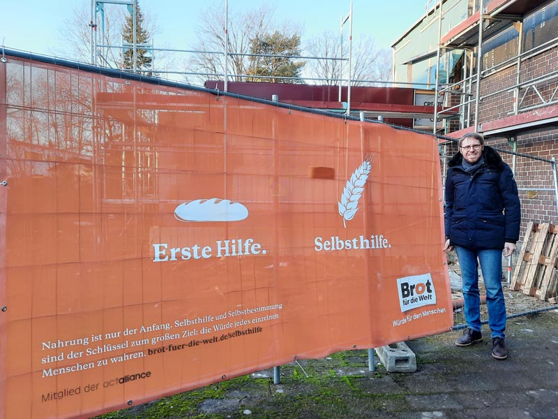 Ein großes Banner wirbt am Bauzaun auf dem Gelände der Christophoruskirche für „Brot für die Welt“. Foto: Hannes Müller